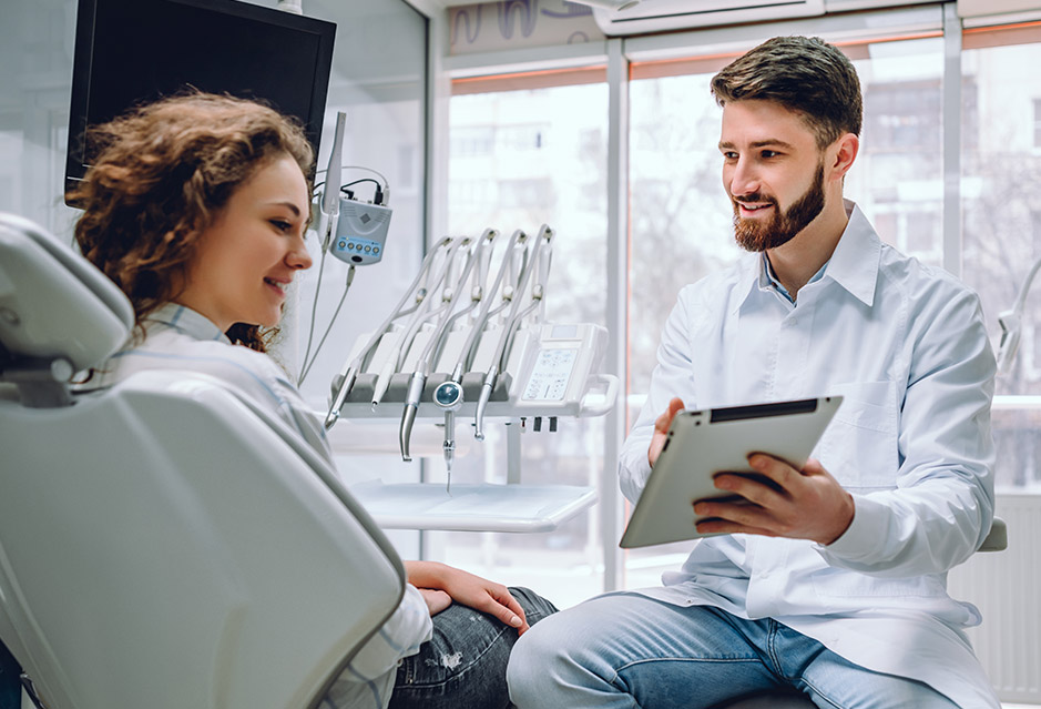 First Dental Visit Expectations | Smiling dentist with smiling female patient