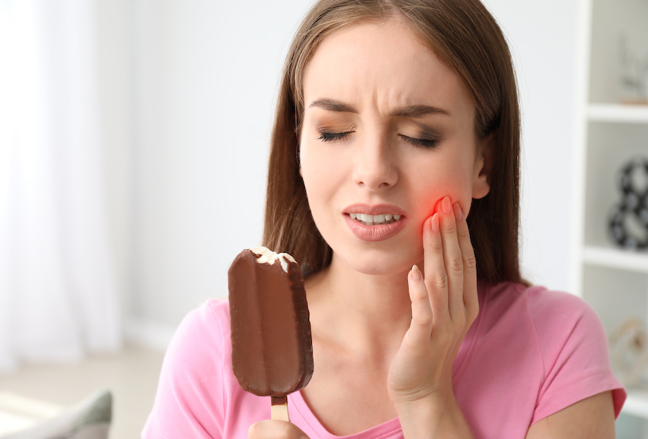 Young woman with sensitive teeth and cold ice-cream at home | What is a Cavity? What Causes Sensitive Teeth? | My Dental Advocate