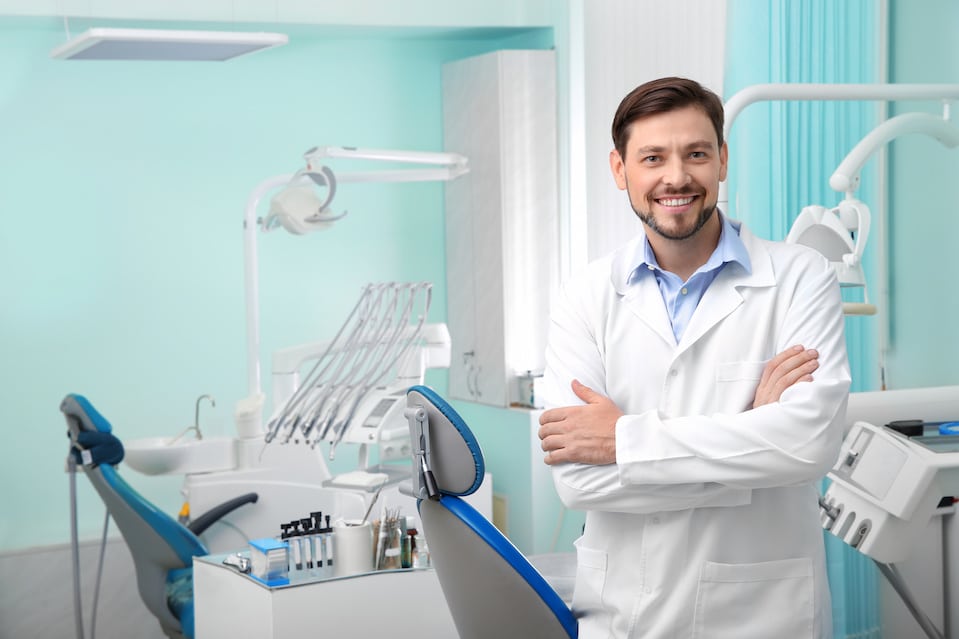 Smiling male dentist in the dental office | My Dental Advocate